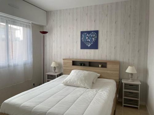 - une chambre avec un grand lit blanc et 2 tables de chevet dans l'établissement Appartement en plein centre d'Arcachon, à Arcachon
