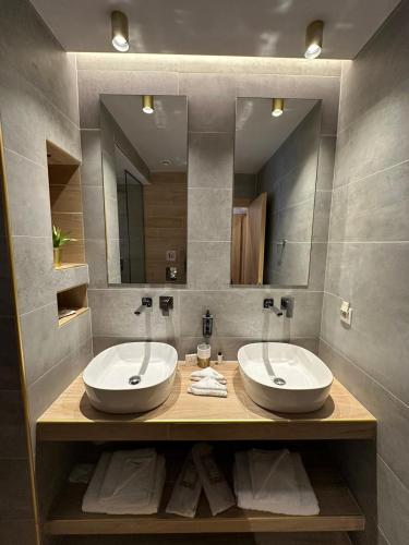 a bathroom with two sinks and a large mirror at Meteora Gold and Glass in Kalabaka