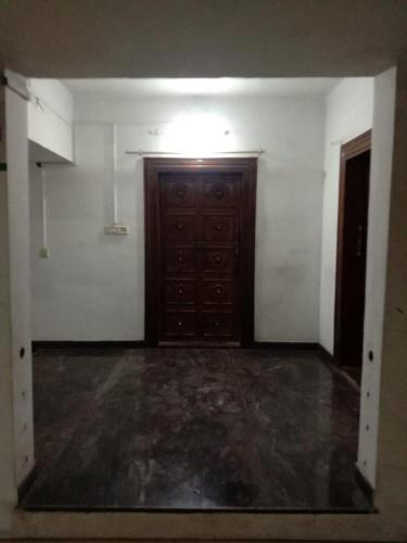 an empty room with a wooden door in a room at Kailas in Kollam
