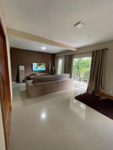 a large living room with a couch and a television at Casa para temporada em Alto Caparaó MG in Caparaó Velho