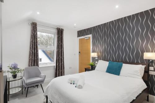 a bedroom with a bed and a chair and a window at Modern city centre studio apartment! in Oxford