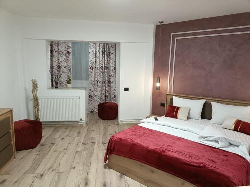 a bedroom with a large bed with a red blanket at Central Train Station Apartment in Braşov