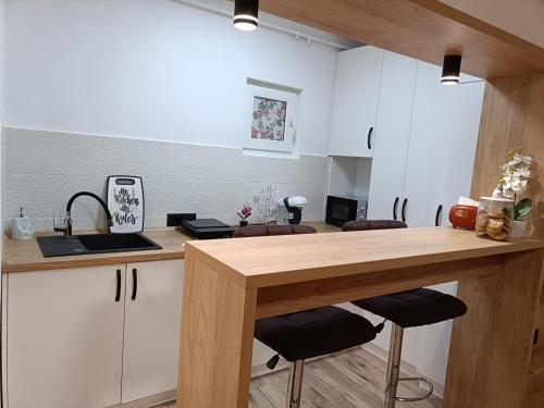 a kitchen with white cabinets and a wooden counter top at Central Train Station Apartment in Braşov