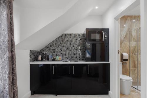 a kitchen with a black refrigerator and a sink at Modern city centre studio apartment in Oxford