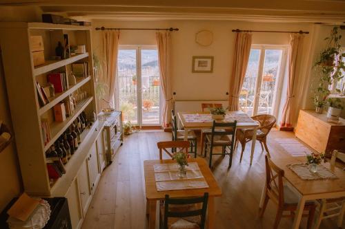 sala de estar con mesas, sillas y ventanas en Dimora Valverde B&B, en Marano di Valpolicella