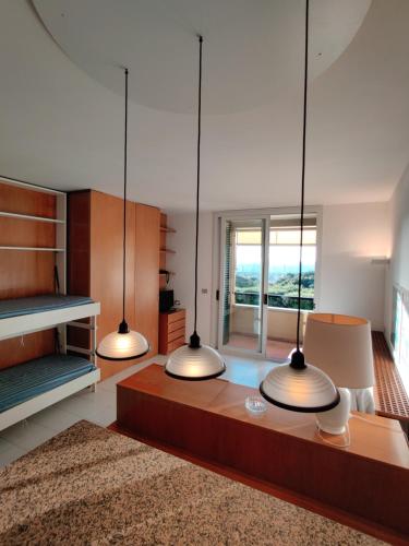 a living room with three lights hanging from the ceiling at Holiday Homes Marina in Punta Ala