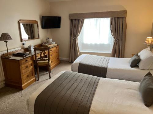 a hotel room with two beds and a desk and a mirror at Best Western Valley Hotel in Ironbridge