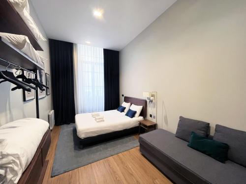 une chambre avec un lit et un canapé dans l'établissement Urban Flat 91 - Beautiful Flat Picasso in Le Marais, à Paris