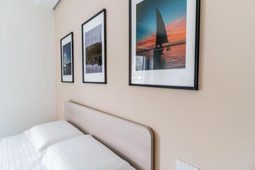a room with four pictures on a wall with a bed at B&B A Un Passo Dal Lago, Caldonazzo in Caldonazzo