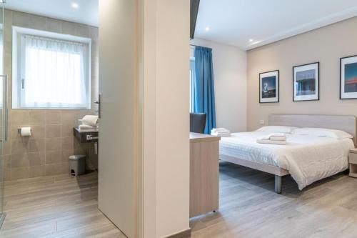 a hotel room with a bed and a bathroom at B&B A Un Passo Dal Lago, Caldonazzo in Caldonazzo
