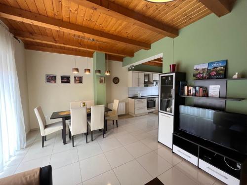 a kitchen and dining room with a table and a television at House Hévíz in Hévíz