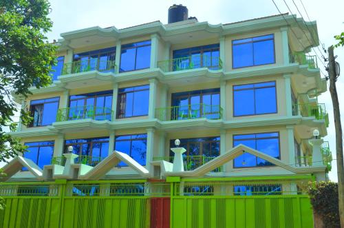 un edificio con una valla verde delante de él en Luxury Budget Hotels en Arusha