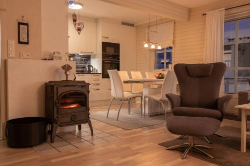 a kitchen and living room with a stove and chairs at Lovely house in Tromso in Tromsø