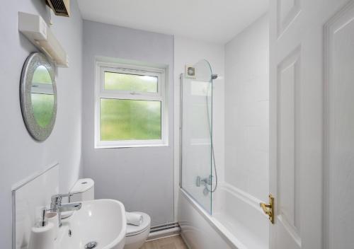 a white bathroom with a sink and a shower at Crawley Thornhill 1 Bed Apartment near Gatwick Airport with Free Parking in Ifield