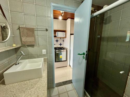 uma pequena casa de banho com um lavatório e um chuveiro em Flat Cumaru ap 210 TEMPORADANOFRANCES Localização privilegiada e conforto na Praia do Francês
