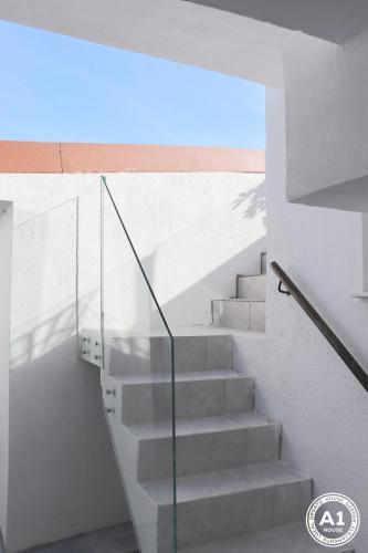 a stairway with a glass railing and a stair case at Oporto House Garden in Porto