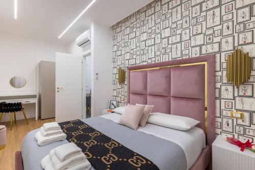 Un dormitorio con una cama grande y una pared de cuadros. en Maison 31 -Luxury Apartments, en Santa Marinella