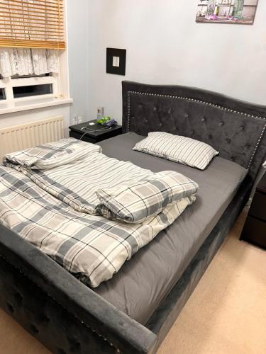 a bed in a bedroom with a black headboard at Five Newcastle Town House in Kenton