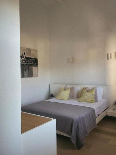 une chambre avec un grand lit avec des oreillers jaunes dans l'établissement Appartement fonctionnel 4p avec piscine et vue mer, à Porto-Vecchio