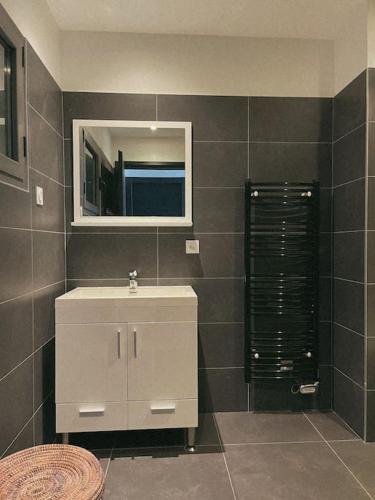 une salle de bain avec un lavabo blanc et un miroir dans l'établissement Appartement fonctionnel 4p avec piscine et vue mer, à Porto-Vecchio