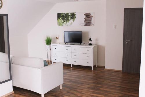 a living room with a tv and a white dresser at Traumhaftes 1-Zimmer Appartement in Roxheim