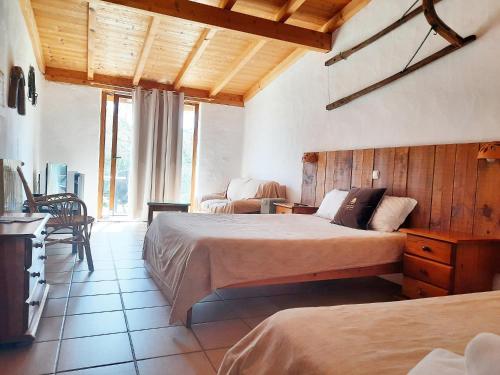 a hotel room with two beds and a living room at Quinta Pedagógica da Samoqueirinha - Duna Parque Group in Vila Nova de Milfontes