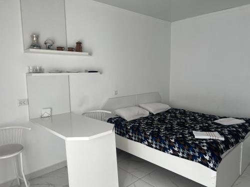 KantにあるОтель «Рублевка»のベッドとデスクが備わる小さな白い客室です。