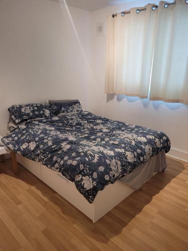 1 dormitorio con 1 cama con edredón blanco y negro en 2 double bedrooms apartment near airport & town, en Dublín