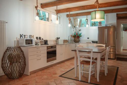 uma cozinha com uma mesa e uma sala de jantar em WELCOME TRAVELLER FRIDA'S ROOMs em Caprino Veronese