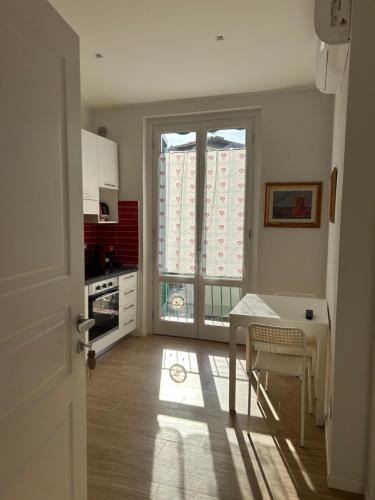 a kitchen with a table and a table and a window at Etrusco Viola - Appartamento "Giglio Viola" in Bagno a Ripoli