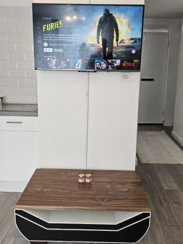 a tv with a movie poster on top of a table at Cozy 2 bed flat in London