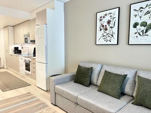 uma sala de estar com um sofá e um frigorífico em Kotimaailma Apartments Tervapääsky I em Oulu