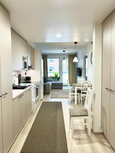 a kitchen and dining room with a table and chairs at Kotimaailma Apartments Tervapääsky I in Oulu