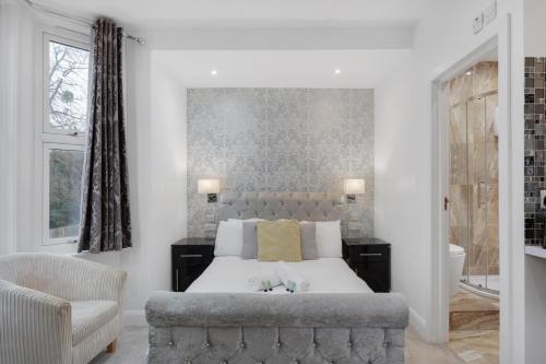 a bedroom with a large bed and a chair at Modern city centre studio apartment 202 in Oxford