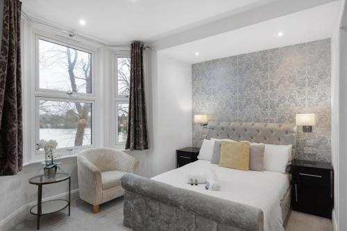 a bedroom with a bed and a chair and a window at Modern city centre studio apartment 202 in Oxford