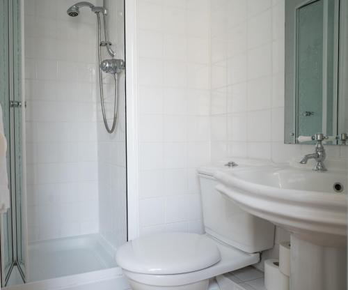 uma casa de banho branca com um WC e um lavatório em Llandudno Hostel em Llandudno