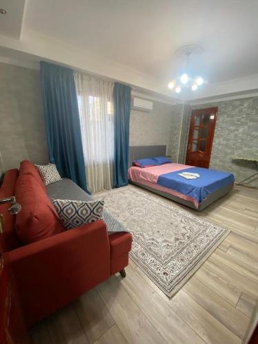 a living room with a bed and a couch at Апартаменты in Shymkent