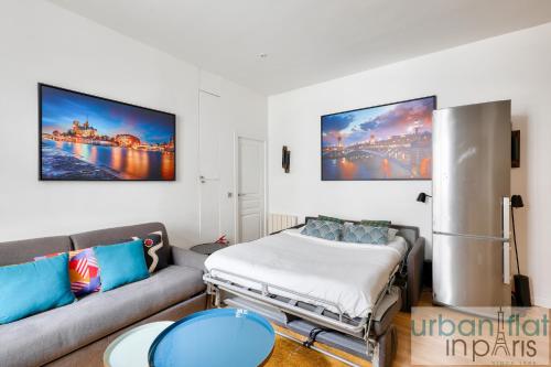 un salon avec un canapé et un lit dans l'établissement 62 - Beautiful Apartment Triangle d- 100m from Champs-Elysees, à Paris