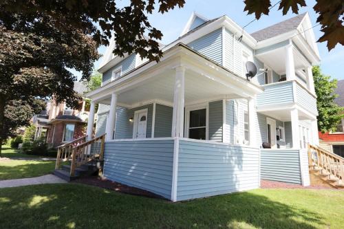 a white house with a porch on a lawn at 2nd Base Apt 1 All Star Baseball Rentals in Oneonta