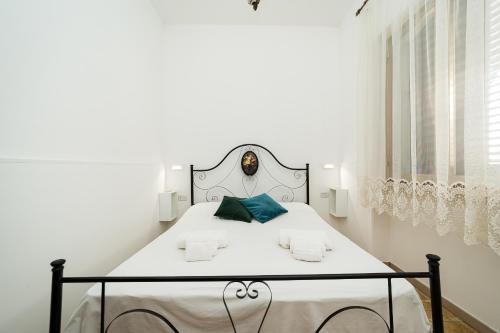 ein weißes Schlafzimmer mit einem weißen Bett mit schwarzem Rahmen in der Unterkunft Casa Silvia By Vivimy in Taviano