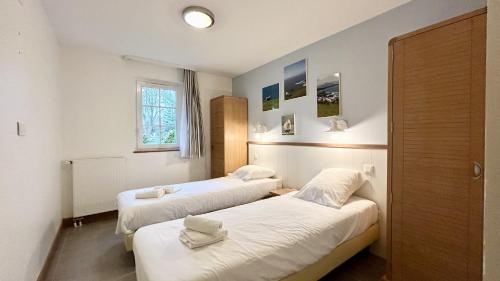 une chambre avec deux lits et une fenêtre dans l'établissement Argousiers 14, à Fort-Mahon-Plage