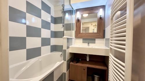 une salle de bain avec un lavabo, une baignoire et un miroir dans l'établissement Argousiers 14, à Fort-Mahon-Plage