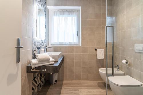 a bathroom with a sink and a toilet and a tub at B&B A Un Passo Dal Lago, Caldonazzo in Caldonazzo