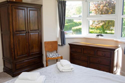 a bedroom with a bed and a dresser and a window at Glenydd Rhydlewis in Rhyd Lewis