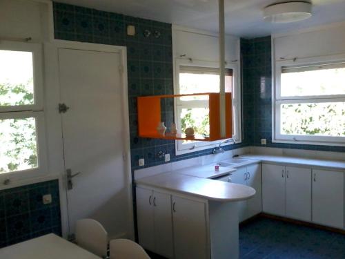 uma cozinha com um lavatório e duas janelas em Casa Vintage delante del mar para 15 huéspedes em San Vicente de Calders