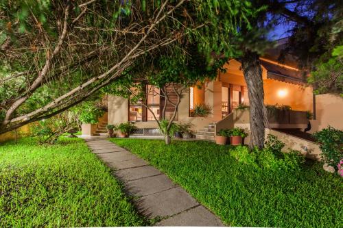 a house with a walkway in front of a yard at La Tuia e il Tasso in Cagliari