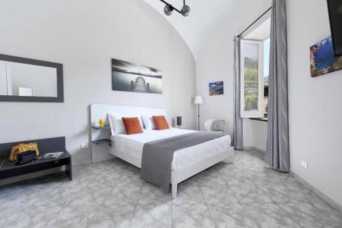 a white bedroom with a bed and a window at Sorrento Realty Holidays Nagy House in Sant'Agnello