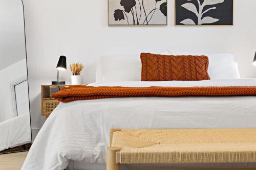 a bedroom with a large bed with white sheets and orange pillows at Lovely Rental Unit with free Parking on Premises in Fort Lauderdale