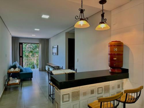 a kitchen and living room with a table and chairs at Apartamentos a 200m do centro - Hospedaria Villa da Pedra in Tiradentes
