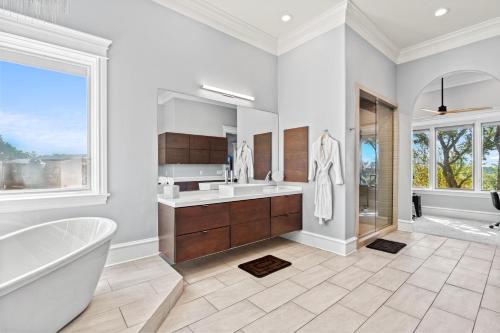 a white bathroom with a tub and a sink at Fortaleza l Luxury 8 BR, 7,000+ sqft Palace on 3 Acres with Pickleball & Basketball Court in Helotes